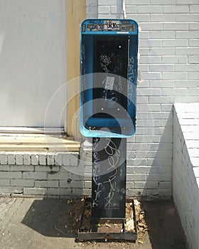 Payphone Remnants and Brick Building Facade