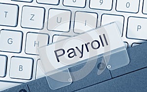 Payroll folder on computer keyboard