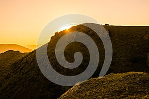 Paysage of hills and silhouettes of people on a sundown