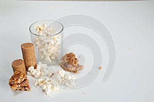 PaÃ§oquinha , popcorn ,  peanuts , pÃ© de moleque and cocada on top of a white background