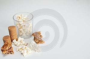 PaÃ§oquinha , popcorn ,  peanuts , pÃ© de moleque and cocada on top of a white background