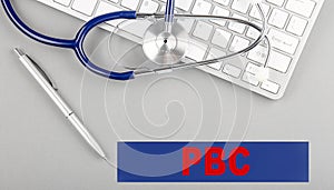 PBC text on keyboard with stethoscope , medical concept