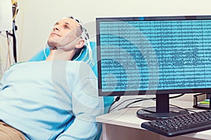 PC displaying brain waves of male patient at lab