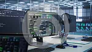 PC screens on server hub office desk showing programming software, close up