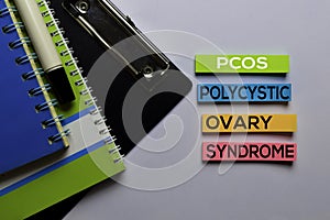 PCOS. Polycystic Ovary Syndrome write on sticky notes. Isolated on white table background photo