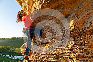 Pcture of curly-haired climber girl climbing rock