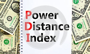 PDI power distance index symbol. Concept words PDI power distance index on white note on a beautiful background from dollar bills