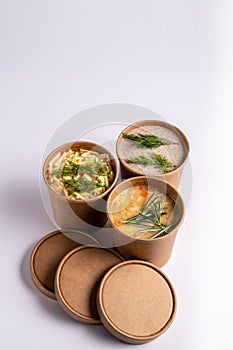 Pea, Mushroom and chicken soup in paper disposable cups for take-out or delivery of food on white background