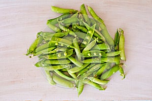 Pea pods on a hill lying on a wooden