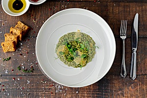 Pea risotto on a white porcelain plate in a fine dining restaurant