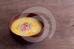 Pea soup with ham and potatoes with spoon on a white background.