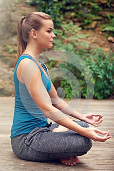Peace is all I need. a young woman practicing yoga outdoors.