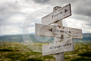 peace freedom prosperity text on wooden signpost