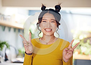 Peace, hands and portrait of Asian woman in home with happiness, v sign or gen z person in kitchen, living room or