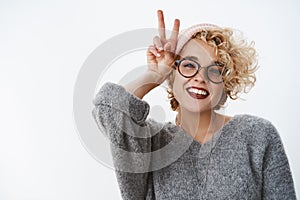 Peace mates how you doing. Portrait of enthusiastic and carefree stylish european modern woman with pierced nose and