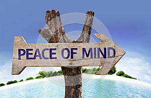 Peace of Mind wooden sign with a beach on background