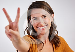 Peace out yall. Studio shot of a young woman showing a peace sign with her hand against a white background.