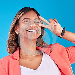 Peace sign, happy and portrait of a woman on a blue background for fashion, comedy and young. Smile, face and an Indian