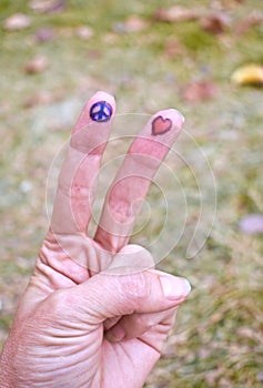 Peace sign and heart shape drawings on fingers