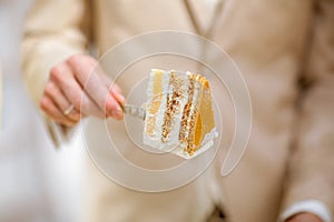 Peace of tasty homemade wedding cake with cream and yellow mousse