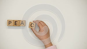 Peace word on cubes made by kid, praying to stop war and violence, broken family