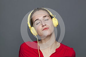 Peaceful 20s girl for trendy headphones concept