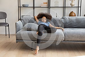 Peaceful African girl kid with curly hair resting on couch