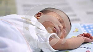 Peaceful asian baby girl lying on a bed while sleeping in a bedroom.