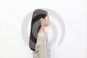 Peaceful Asian little girl closed eyes isolated on white background. Portrait of kid with long black hair, Side view