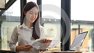 Peaceful asian woman sitting in coffee shop and reading book