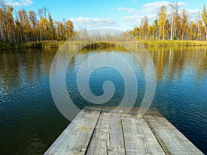 Peaceful autumn scene near a small lake: a deserted jetty used for bathing
