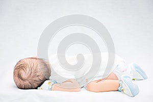 Peaceful baby lying on a bed while sleeping.