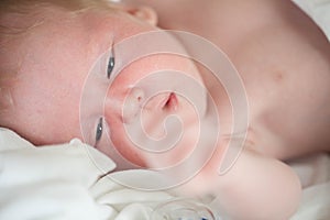 Peaceful baby lying on a bed while sleeping in a bright room