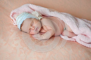 Peaceful baby lying on a bed while sleeping in a bright room