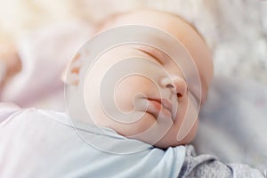 Peaceful baby lying on a bed while sleeping in a bright room