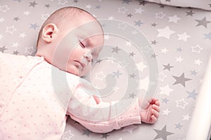 Peaceful baby lying on a bed while sleeping, top view