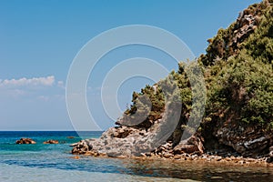 Peaceful beach with golden island and sand at sunset, sea with calm water, Greece.