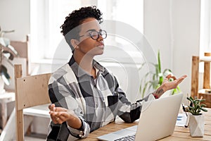 Peaceful black girl practice yoga at workplace