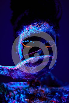 peaceful black woman with creative fluorescent prints on skin, on body, close mouth