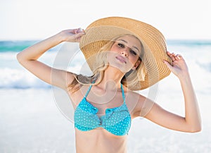 Peaceful blonde in bikini wearing straw hat