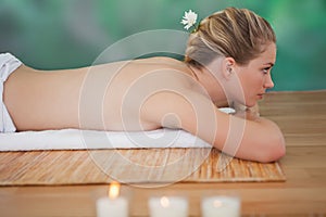 Peaceful blonde lying on bamboo mat