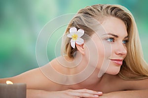 Peaceful blonde lying on towel with candle