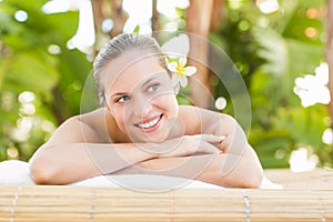 Peaceful blonde lying on towel with candle