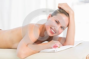 Peaceful blonde lying on towel smiling at camera