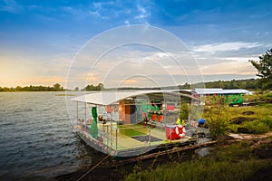 Peaceful blue lake with green grass and blue sky background. Beautiful blue sky and clouds over the reservoir. Rafting activity i