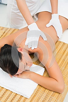 Peaceful brunette enjoying an exfoliating back massage