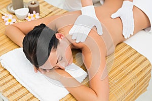 Peaceful brunette enjoying an exfoliating back massage