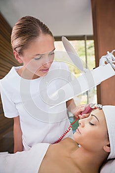 Peaceful brunette getting micro dermabrasion from beauty therapist