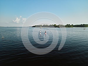 A peaceful and calm lake scene featuring paddleboarders enjoying their time on a sunny day photo