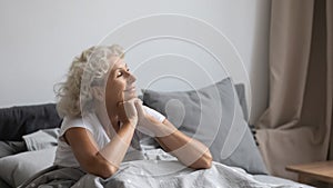 Peaceful middle aged woman welcoming new day in bedroom. photo